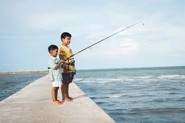 Сын и папа рыбачат в море — стоковое фото