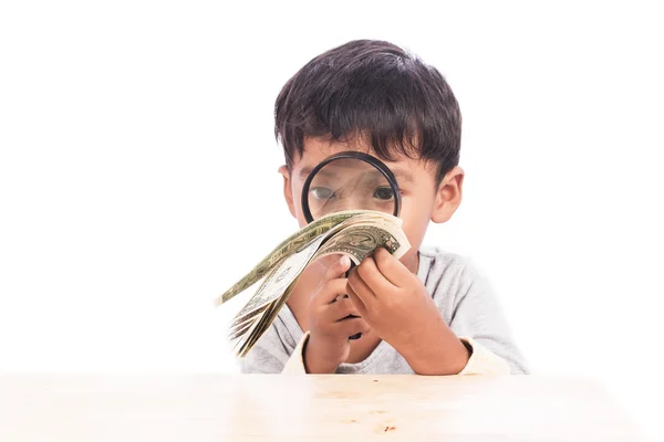 Χαριτωμένο μικρό αγόρι να χρησιμοποιήσετε τον μεγεθυντικό φακό ψάχνει χρήματα — Φωτογραφία Αρχείου