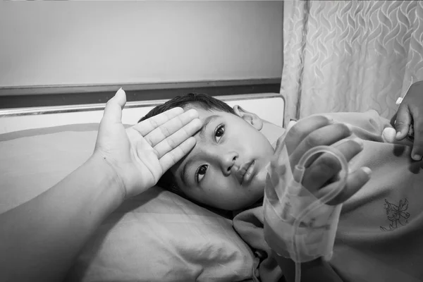 Anya az ágyban, fekete pihenés közben fia beteg ellenőrizni a láz — Stock Fotó