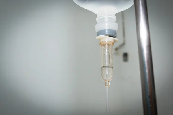 Somministrazione ravvicinata della flebo di soluzione fisiologica per il paziente e della pompa per infusione in hospita — Foto Stock
