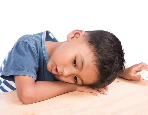 Close up of cute little boy laying on table — Stock Photo, Image