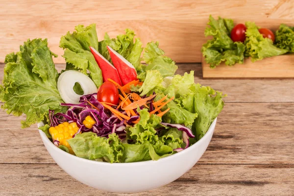 Salade de légumes sur fond bois — Photo