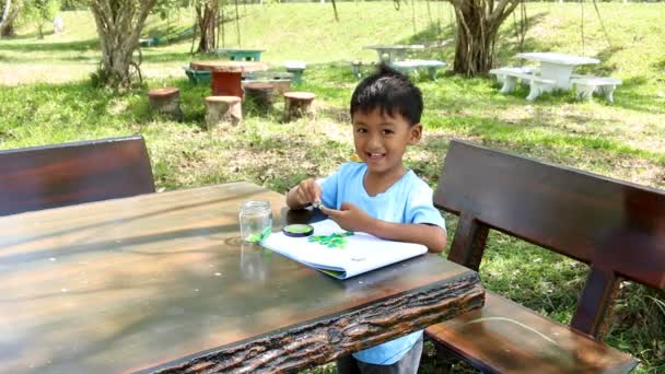 Małe dzieci zrobić pracę domową sztuki w parku — Wideo stockowe