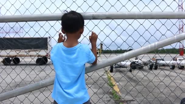 Little boy standing alone and sad at cage — Stock Video