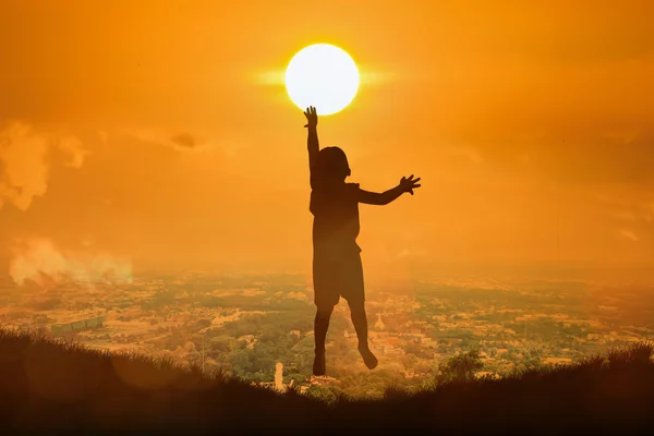 Silueta de niño feliz salto toque el sol, puesta del sol backgrou —  Fotos de Stock