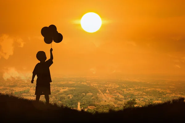 Silueta de niño pequeño mantenga burbuja mira al sol, puesta de sol —  Fotos de Stock