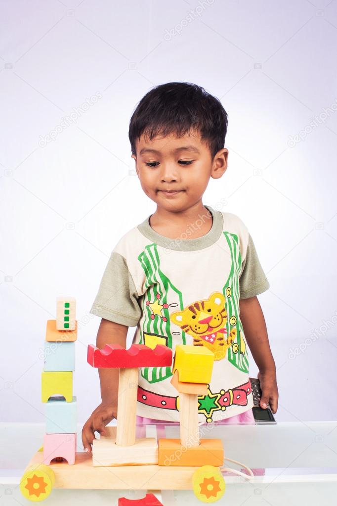 a little asian boy play toy block wooden