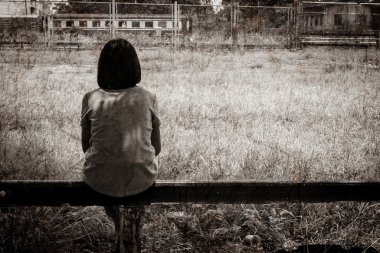 Yalnız tren istasyonları yakınında oturan üzgün Asyalı kız