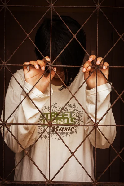 Девушка, стоящая за тюрьмой — стоковое фото