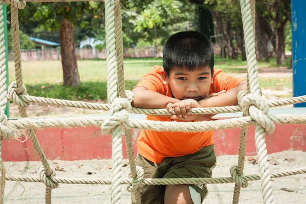 Asiatico ragazzo seduta da solo a parco giochi — Foto Stock