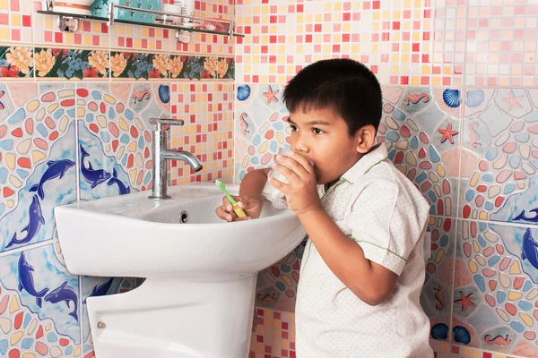 Милий маленький хлопчик чистить зуби в пральній кімнаті — стокове фото