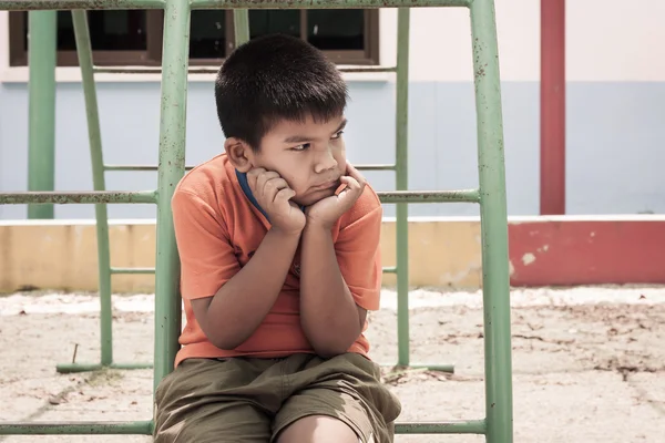 Asiático menino sentado sozinho no playground, vintage tom — Fotografia de Stock