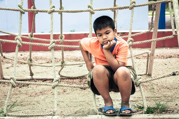 Asiático menino sentado sozinho no playground, vintage tom — Fotografia de Stock