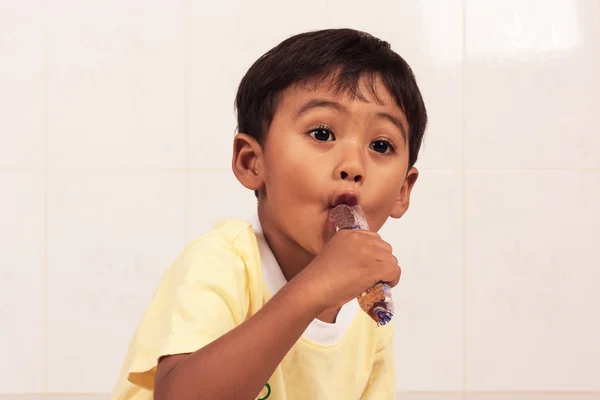 Маленький азіатський хлопчик їсть лід — стокове фото