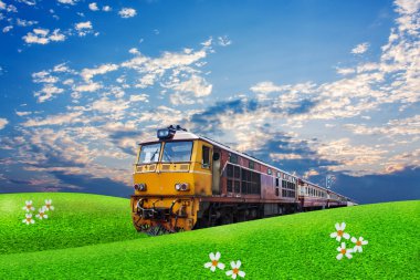 Mavi gökyüzü arka plan üzerinde yeşil alan üzerinden tren geçer