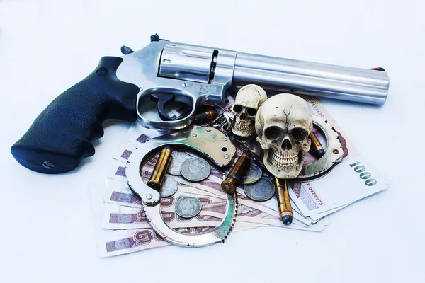 Calavera humana con esposas y revólver, bala .375 en bac dinero —  Fotos de Stock
