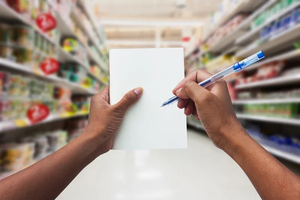 Les femmes de main faisant leurs courses et tenant un carnet vide pour la liste de contrôle — Photo