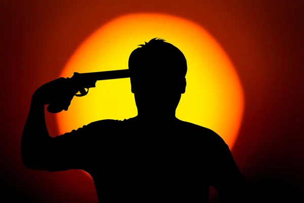Silueta del joven se suicida con su revólver —  Fotos de Stock