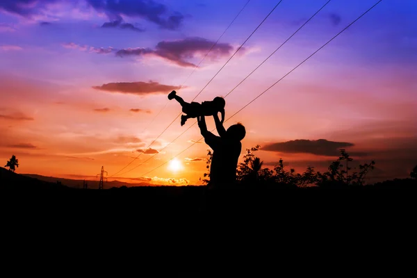 Silhuetas de pai e filho jogar na gama de montanha e alta vo — Fotografia de Stock