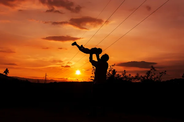 Silhuetas de pai e filho jogar na gama de montanha e alta vo — Fotografia de Stock