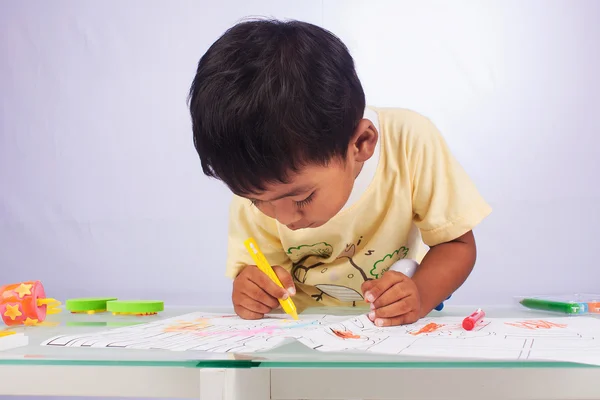 Маленький азіатський хлопчик малює колір на білому папері в кімнаті — стокове фото