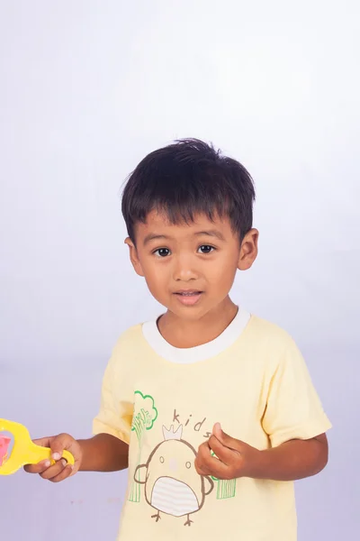 Um pouco asiático menino pintura no branco packground — Fotografia de Stock