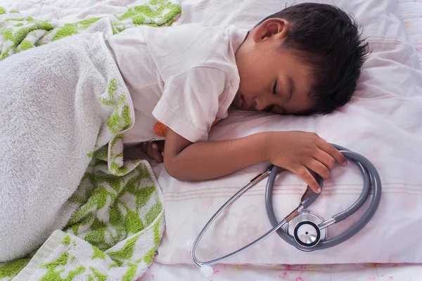 Un poco asiático chico dormir y mano hold estetoscopio —  Fotos de Stock