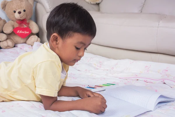 Un peu asiatique garçon peinture sur blanc livre dans la chambre — Photo