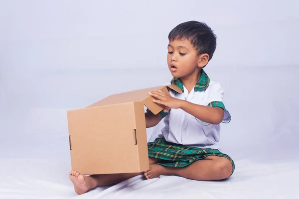 Retrato de asiático menino jogar caixa marrom no fundo branco — Fotografia de Stock