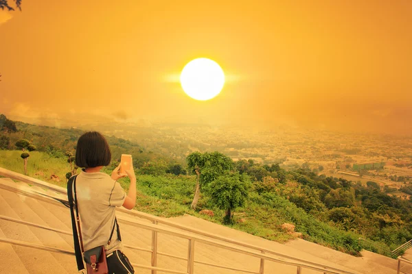 Азіатська дівчина робить фото захід сонця — стокове фото