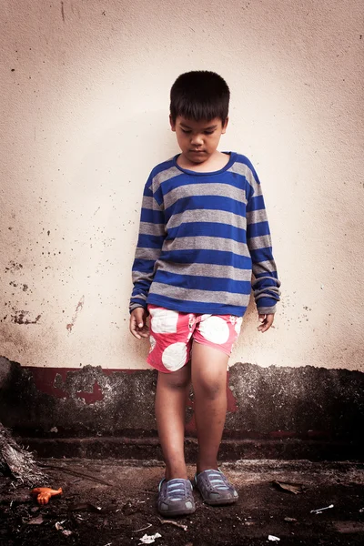 Ásia menino triste sozinho perto de idade parede cimento, vintage tom — Fotografia de Stock