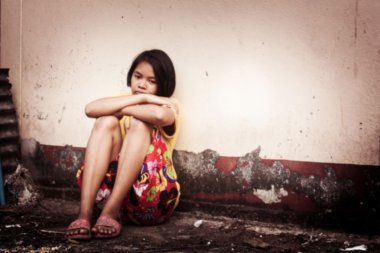 Asyalı kız üzgün yalnız oturan eski duvar çimento, VI yakınındaki bulanık