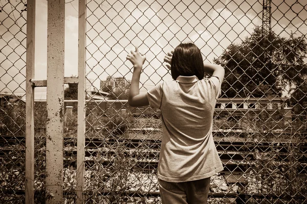 Asiatiska liten flicka sorgliga hand hålla fängelse på järnväg, järnvägsstationen — Stockfoto