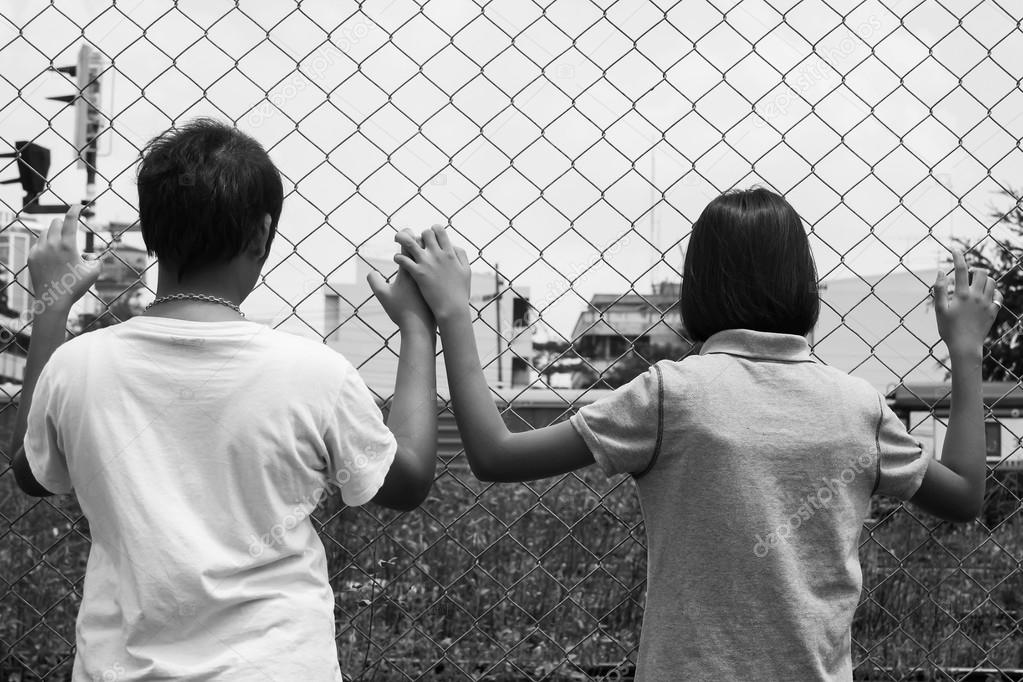 asian little girl sad hand hold jail at Railroad,railway station