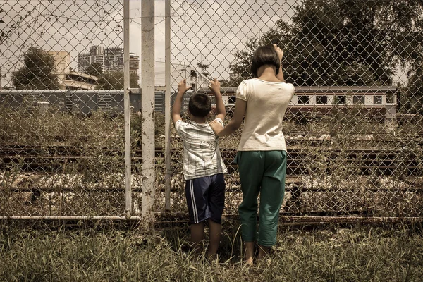 Asian girl and boy sad  hand hold jail at Railroad,railway stati — Stock Photo, Image