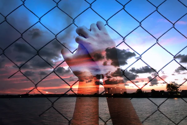Doppelbelichtung von asiatischen Mädchen Hand halten Gefängnis auf Sonnenuntergang an der se — Stockfoto