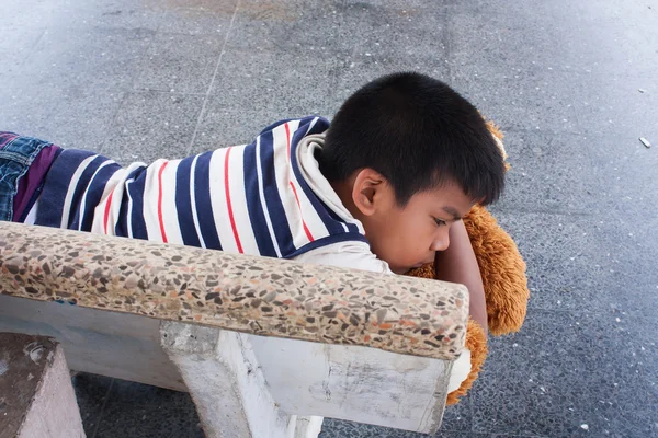 Menino dorme sozinho na estação de trem — Fotografia de Stock