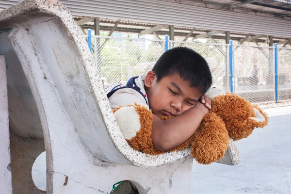 Мальчик спит один на вокзале. — стоковое фото