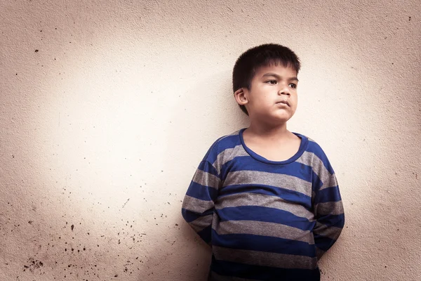 Asiático menino triste sozinho de pé perto de idade parede cimento, vintage tom — Fotografia de Stock