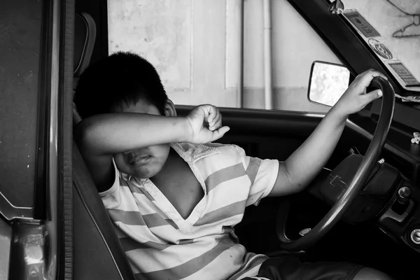 The boy sad alone in the old car, black and white — стоковое фото