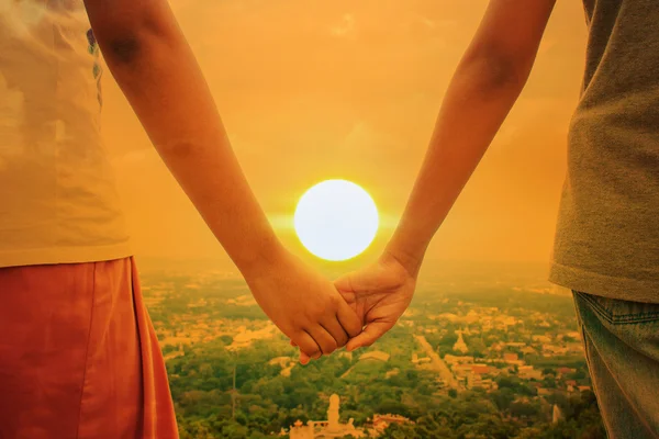 Glücklich niedlich Hand Kind Mädchen Paar hält Sonnenuntergang Hintergrund — Stockfoto