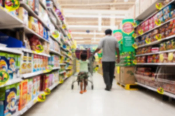 Borrão de pai e filho caminham fazendo compras no supermercado — Fotografia de Stock