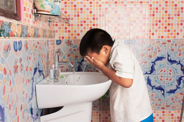 Маленький хлопчик чистить обличчя у ванній — стокове фото