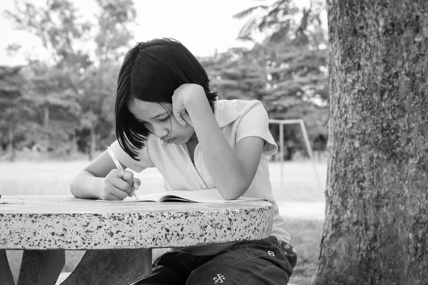 귀여운 아시아 소녀는 공원에서 흑인과 백인 책을 읽고 — 스톡 사진
