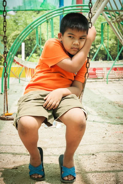 Азиатский мальчик грустно в одиночестве на детской площадке — стоковое фото