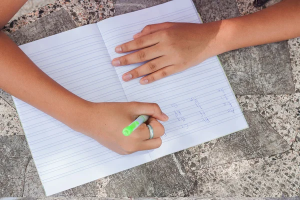 Hand meisje schrijven boek — Stockfoto