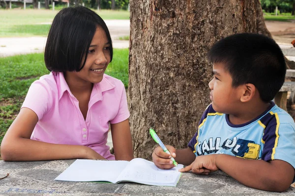 Bonito menina e menino escrevendo livro no jardim — Fotografia de Stock