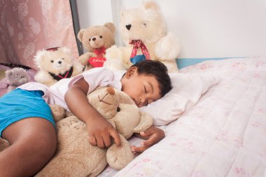 küçük Asyalı çocuk uyku oyuncak ayı ile