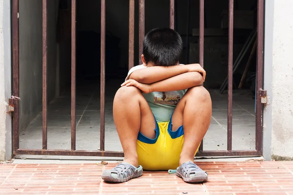 Little boy sad sitting alone near old jail — Stock Photo, Image