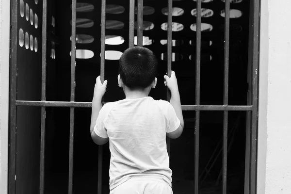 Pequeño niño celebrar la cárcel, negro y blanco tono — Foto de Stock